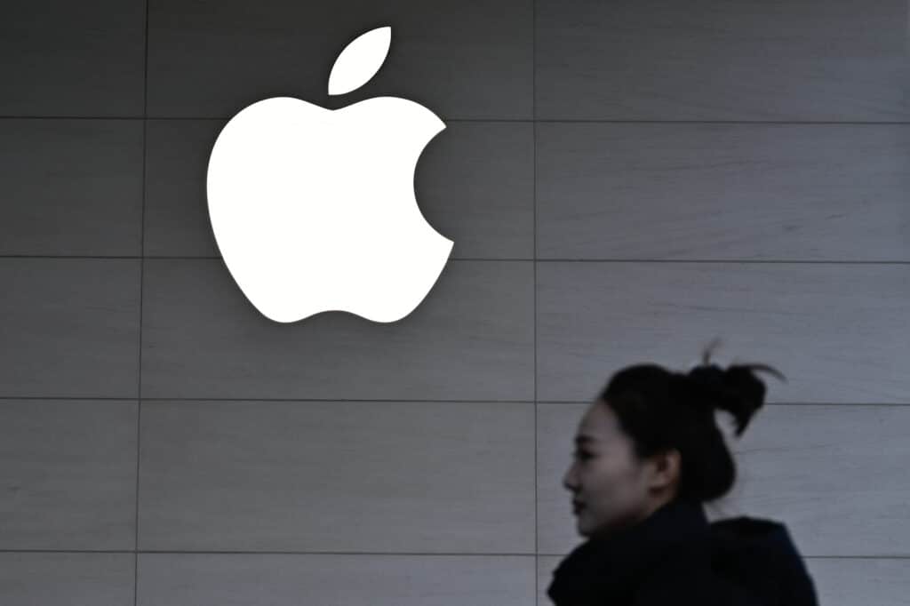 Apple: Lower-priced iPhone 16e added to line-up. A woman walks past a logo of the Apple store in Beijing on February 13, 2025. (Photo by Pedro PARDO / AFP)