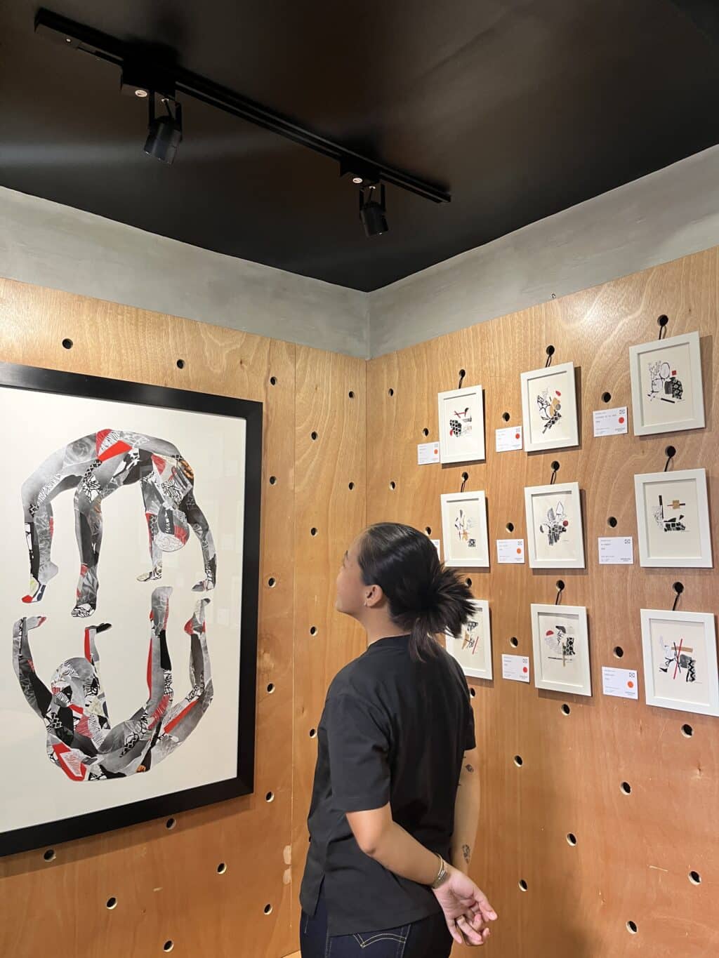 Artist, Gerlynnia Galgo, looks at her work at her first solo show