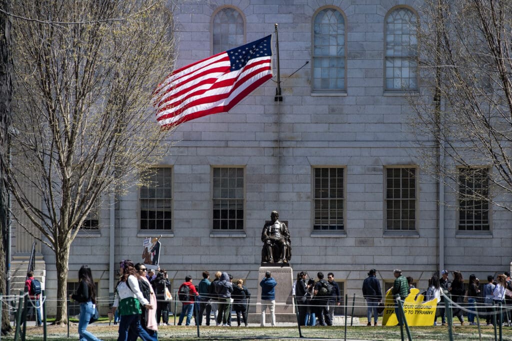 Harvard’s right to enroll foreign students revoked by US gov’t, (FILE) Demonstrators with signs stand around the John Harvard Statue in Harvard Yard following a rally against President Donald Trumps attacks on Harvard University at Harvard University in Cambridge, Massachusetts on April 17, 2025.(Photo by Joseph Prezioso / AFP)